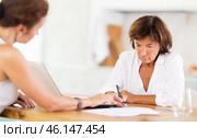 Woman listen attentively and intently to woman of seller, who tells about advantages of making microloan in credit institution. Стоковое фото, фотограф Яков Филимонов / Фотобанк Лори
