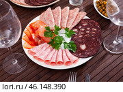 Slices of Spanish dry-cured gammon, variety of sausages. Стоковое фото, фотограф Яков Филимонов / Фотобанк Лори