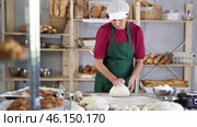Woman works in bakery as baker, kneads dough, works with flour. Стоковое видео, видеограф Яков Филимонов / Фотобанк Лори