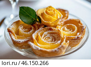 Delicate rose-shaped pastries dusted with powdered sugar, beautifully arranged on a glass plate, showcasing fine patisserie craftsmanship. Стоковое AI-изображение, AI-художник Башкирова Анна / Фотобанк Лори