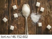 Sugar pile in a metal spoon on a wood surface. White granulated sugar and cubes. Natural seasoning. Refined sugar poured on wooden rustic table. Sugary sand. Cooking, cosmetology, spa services concept. Стоковое AI-изображение, AI-художник Марина Демидюк / Фотобанк Лори