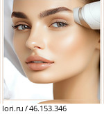 Close-up of a woman's face with perfectly smooth skin. The cosmetic procedure is performed with a device for skin care in the forehead area. The woman has expressive blue eyes, thick eyebrows and full lips. Her skin looks radiant, moisturized and well-groomed, which emphasizes the professional facial care.The background is light and minimalistic, creating an atmosphere of luxury and aesthetics. The image conveys the idea of ​​modern cosmetology, rejuvenation and self-care. Стоковое AI-изображение, AI-художник Анна Кривицкая / Фотобанк Лори