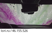 Thick foam, which abundantly covers whole car. Camera focuses on how foam slowly spreads along hood, roof and side sides of car. You can see how she envelops every detail. Стоковое видео, видеограф Скрипачев Антон / Фотобанк Лори