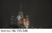 Moscow January 08 2021, Focus is majestic Cathedral of Blessed Vasily, whose multi colored domes sparkle light of festive illumination. Snowflakes are quietly spinning in air, adding scene of magic. Редакционное видео, видеограф Скрипачев Антон / Фотобанк Лори