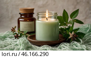 A mock-up of a comfortably burning candle made of glass with an empty white label and greenery in a home interior. Стоковое AI-изображение, AI-художник Photojuli / Фотобанк Лори