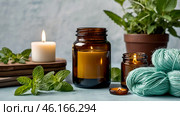 A mock-up of a comfortably burning candle made of glass with an empty white label and greenery in a home interior. Стоковое AI-изображение, AI-художник Photojuli / Фотобанк Лори