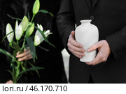 Couple with mortuary urn and flowers at funeral. Стоковое фото, фотограф Pixel_shot / Фотобанк Лори