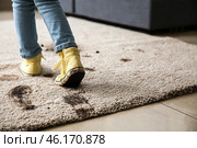 Little girl in muddy shoes messing up carpet at home. Стоковое фото, фотограф Pixel_shot / Фотобанк Лори