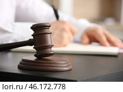 Male lawyer signing documents and judge gavel at table in office, closeup. Стоковое фото, фотограф Pixel_shot / Фотобанк Лори