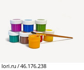 Много разноцветных баночек с краской, с кисточкой, на белом фоне, для рисования, крупным планом, с местом для текста. Many multi-colored paint cans with a brush on a white background for drawing, close-up, with space for text. Стоковое фото, фотограф Наталья Пеньшина / Фотобанк Лори