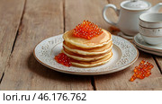 Russian traditions. Russian holiday Maslenitsa. Still life with a pile of pancakes and red caviar on a light beige background. Стоковое AI-изображение, AI-художник Photojuli / Фотобанк Лори
