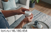 Person engaging with smart home device in modern living room setting. Стоковое видео, видеограф Zakharova Natasha / Фотобанк Лори
