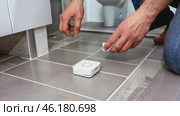 Installing home wireless sensor on bathroom floor tiles for smart home safety. Стоковое видео, видеограф Zakharova Natasha / Фотобанк Лори