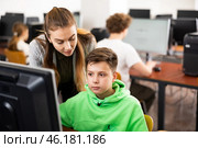Female teacher consulting tween boy studying in computer class. Стоковое фото, фотограф Яков Филимонов / Фотобанк Лори
