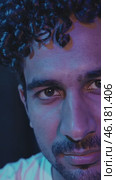 Introspective young man with curly hair posing under colored lights. Стоковое видео, видеограф Данил Руденко / Фотобанк Лори