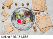 Passover Seder plate with traditional food, walnuts and matza on light background. Стоковое фото, фотограф Pixel_shot / Фотобанк Лори