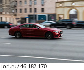 Car Mercedes CLS Class on the road in motion. Fast speed drive on city road. Front side view of moving red car on the street. Редакционное фото, фотограф Константин Григорьев / Фотобанк Лори