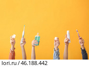 Female hands with toothbrushes, paste, mouth rinse and dental floss on color background. Стоковое фото, фотограф Pixel_shot / Фотобанк Лори