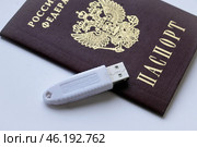 Устройство  USB eToken  (рутокен) белого цвета, устройство для хранения электронной цифровой подписи (ЭЦП) и информации для аутентификации пользователя и паспорт на белом фоне. Редакционное фото, фотограф Snezka / Фотобанк Лори