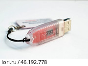 Устройство  USB eToken  (рутокен) – электронная подпись - бкрасного цвета   на белом фоне. Редакционное фото, фотограф Snezka / Фотобанк Лори