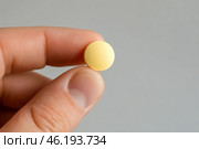 Yellow ball balanced on a fingertip against a dark background during daylight. Стоковое AI-изображение, AI-художник Юлия Гапеенко / Фотобанк Лори