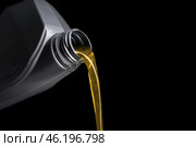 Pouring of motor oil from canister against black background, closeup. Стоковое фото, фотограф Pixel_shot / Фотобанк Лори