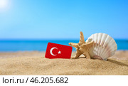 Tropical beach with seashells and Turkey flag. The concept of a paradise vacation on the beaches of Turkey. (2021 год). Стоковое фото, фотограф Никита Бурденков / Фотобанк Лори