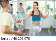 Couple in comfortable sports clothes learns boogie woogie dancing during individual lesson. Стоковое фото, фотограф Яков Филимонов / Фотобанк Лори