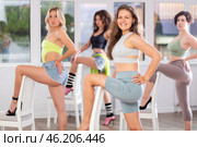 Group of girls unleash their energy and dance passionately near a chair in high heels in a dance studio. His powerful moves combined with elegance of high heels. Стоковое фото, фотограф Яков Филимонов / Фотобанк Лори