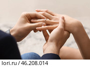 Young man putting ring on finger of his fiancee after marriage proposal, closeup. Стоковое фото, фотограф Pixel_shot / Фотобанк Лори