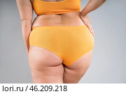 Overweight thigh, woman with fat hips, legs and buttocks, obesity female body with cellulite on gray background. Стоковое фото, фотограф Станислав Тарко / Фотобанк Лори