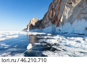 Baikal Lake in sunny cold February day. View of icy rocks of the famous Cape Sagan-Khushun or Three Brothers Rocks in north of Olkhon Island from blue ice with cracks and frozen ice floes. Стоковое фото, фотограф Виктория Катьянова / Фотобанк Лори