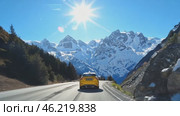 Yellow taxi driving on mountain road with snowy peaks. Стоковое AI-видео, аниматор Юрий Поздников / Фотобанк Лори