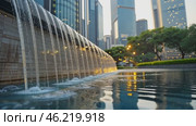 Water falling into fountain in modern cityscape at sunset. Стоковое AI-видео, аниматор Юрий Поздников / Фотобанк Лори