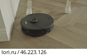 round robot vacuum moves methodically across the bathroom floor, its sensors scanning for dust and hair. Стоковое видео, видеограф Feruza Tashmetova / Фотобанк Лори
