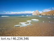 Baikal Lake in spring sunny day. Beautiful landscape with melting ice floes on sandy beach at Khuzhir village of Olkhon Island. View of natural landmark - famous Shamanka Rock. Spring travels and outdoors. Стоковое фото, фотограф Виктория Катьянова / Фотобанк Лори
