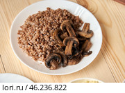 Buckwheat with mushrooms simplicity and modesty Buckwheat with mushrooms on a wooden background symbolizes simplicity and modesty, which help believers focus on spiritual life during Lent. Стоковое фото, фотограф Скрипачев Антон / Фотобанк Лори