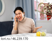 Asian woman swears at someone while talking on a mobile phone. Стоковое фото, фотограф Яков Филимонов / Фотобанк Лори