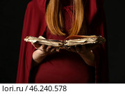 Young witch with spell book on dark background, closeup. Стоковое фото, фотограф Pixel_shot / Фотобанк Лори