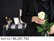 Grieving young woman with rose at funeral, closeup. Стоковое фото, фотограф Pixel_shot / Фотобанк Лори