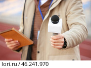 Male reporter with microphone at the stadium, closeup. Стоковое фото, фотограф Pixel_shot / Фотобанк Лори