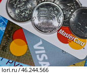 Рублевые монеты и кредитные карточки с логотипами MasterCard и Visa. Редакционное фото, фотограф E. O. / Фотобанк Лори