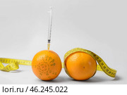 Fresh oranges with measuring tape and syringe on light background. Breast augmentation concept. Стоковое фото, фотограф Pixel_shot / Фотобанк Лори