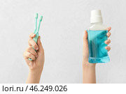 Female hands with toothbrushes and mouth rinse on light background. Стоковое фото, фотограф Pixel_shot / Фотобанк Лори