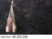 Hanging ballet shoes on dark wall. Стоковое фото, фотограф Pixel_shot / Фотобанк Лори