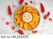 Plate with tasty nachos and bowl of chipotle sauce on light background. Стоковое фото, фотограф Pixel_shot / Фотобанк Лори