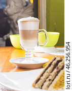 Glass cup of layered coffee latte on table. Стоковое фото, фотограф Сергей Толмачёв / Фотобанк Лори