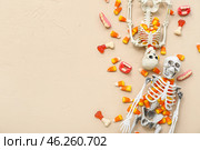 Tasty Halloween candy corns and skeletons on beige background. Стоковое фото, фотограф Pixel_shot / Фотобанк Лори