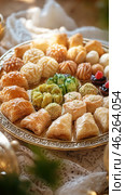 Oriental tray displaying baklava, maamoul, and other delectable middle eastern pastries. Стоковое AI-изображение, AI-художник Юрий Поздников / Фотобанк Лори