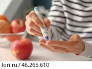 Diabetic woman taking blood sample with lancet pen at home, closeup. Стоковое фото, фотограф Pixel_shot / Фотобанк Лори